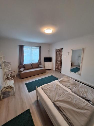 a living room with a bed and a couch at Levendula Porta in Balatonfůzfő