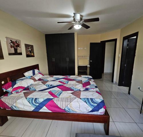 a bedroom with a bed and a ceiling fan at Departamento amoblado Tonsupa in Tonsupa