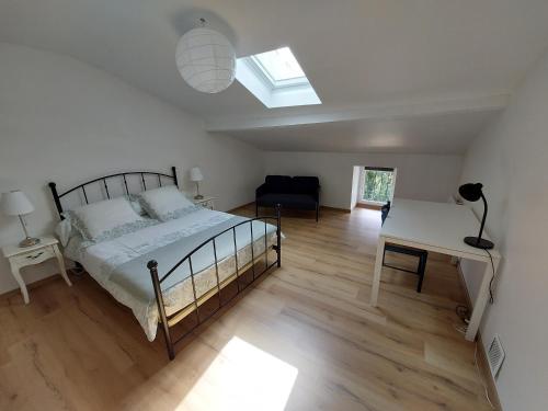 a bedroom with a bed and a desk and a window at Gite des Anglais in Marnay
