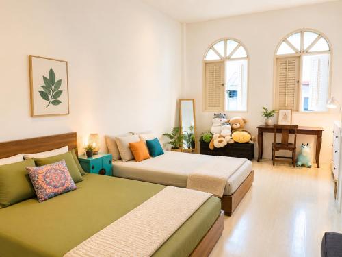 a bedroom with two beds and two windows at Georgetown Kyash House 23 in George Town