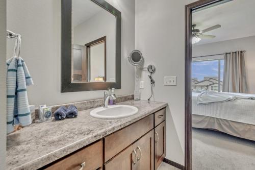 a bathroom with a sink and a mirror and a bed at Bridges Bay Vacation Cabin 185 in Arnolds Park