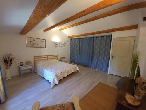 a bedroom with a bed in a room with wooden ceilings at Au 3 bis in Caderousse