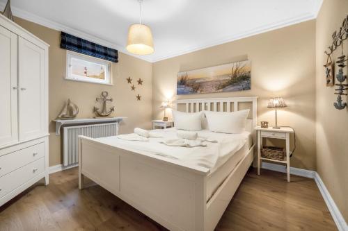 a bedroom with a large white bed in a room at Lööws Roos in Wenningstedt