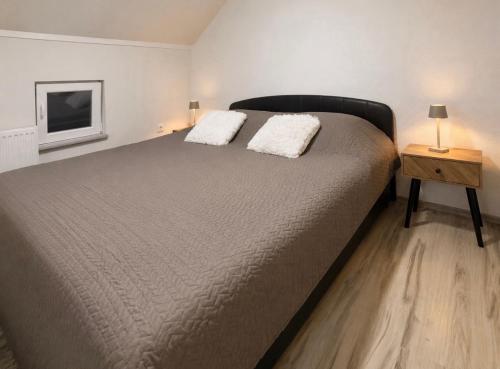 a bedroom with a large bed with two white pillows at Domaćinstvo Kondić in Podovi