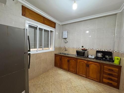 a kitchen with a refrigerator and a sink in it at Larache City Apartment in Larache