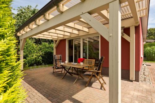 a patio with a table and chairs under a pergola at FH Wendorff in Klink