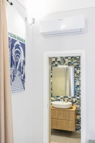 a bathroom with a sink and a mirror at Barrio La Suite del Borgo Bacoli in Bacoli