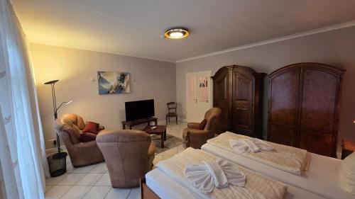 a living room with a bed and chairs and a tv at Altstadt Zauber in Waren