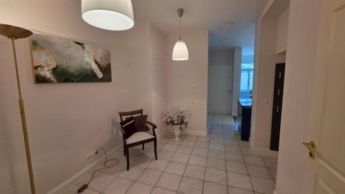 a hallway with a chair and a painting on the wall at Altstadt Zauber in Waren