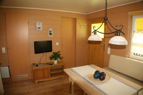a living room with a table and a tv at Bungalow Seedorf 4 in Basedow