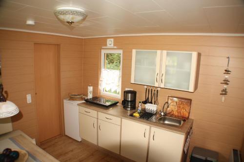 a kitchen with white cabinets and a window at Bungalow Seedorf 4 in Basedow