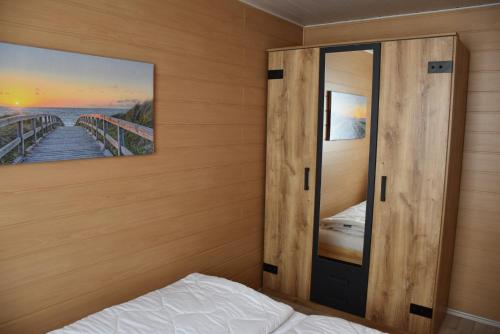 a bedroom with a door and a bed and a painting at Bungalow Seedorf 6 in Basedow