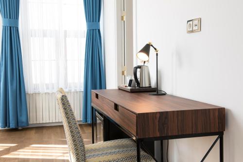 a desk with a lamp and a chair next to a window at Rodosto Hotel in Tekirdag