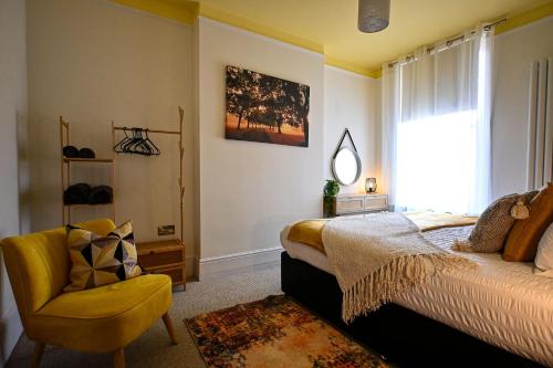 a bedroom with a bed and a chair and a window at Radnor Rest in Folkestone
