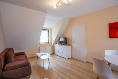a living room with a couch and a table at Am Müritzer Hafen App 4 in Waren