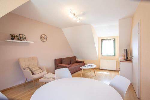 a living room with a couch and a chair at Am Müritzer Hafen App 4 in Waren
