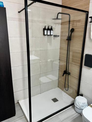 eine Dusche mit Glastür im Badezimmer in der Unterkunft Miravent Terraza y Jardin Frente al mar Menorca in Fornells