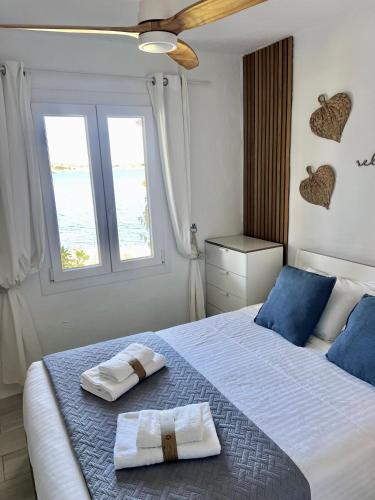 ein Schlafzimmer mit einem Bett, auf dem zwei Handtücher liegen in der Unterkunft Miravent Terraza y Jardin Frente al mar Menorca in Fornells