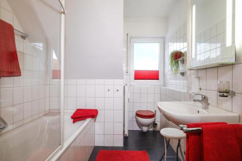 a bathroom with a sink and a tub and a toilet at Ferienwohnung Argenpark Kressbronn in Kressbronn am Bodensee