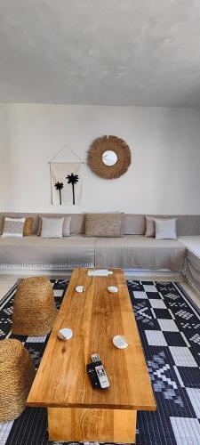 a living room with a wooden table and a couch at Villa Nour Kélibia in Kelibia