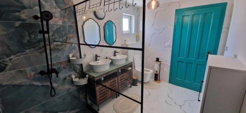 a bathroom with two sinks and a green door at Dãnu Guesthouse in Kravany nad Dunajom