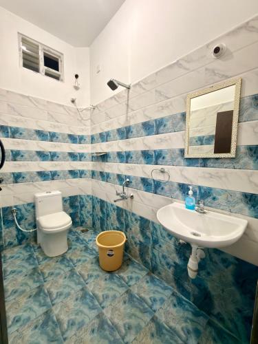 a blue and white bathroom with a sink and a toilet at LuXus Resort & Swimming Pool in Pondicherry