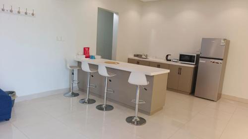 a kitchen with a counter with stools and a refrigerator at روشيلا in Al Majma'ah