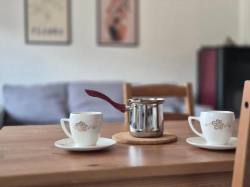 a wooden table with two coffee cups and a juicer at Drinika in Foča