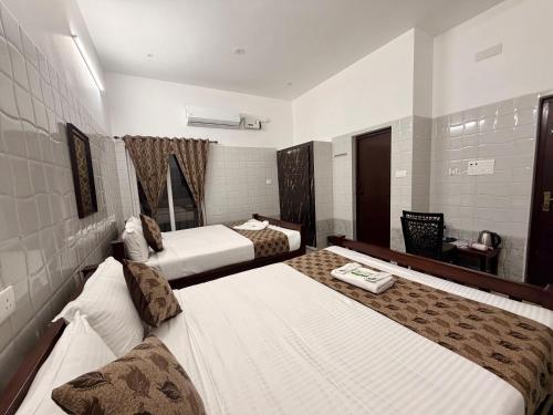 a hotel room with two beds in a room at LuXus Resort & Swimming Pool in Pondicherry
