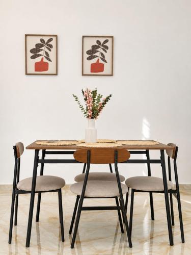 a dining room table with chairs and a vase with flowers at Alojamiento en Miches in Miches
