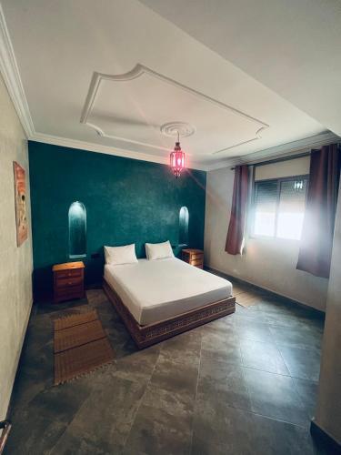 a bedroom with a bed and a blue wall at Zakar Apartments & Terrace in Mirleft