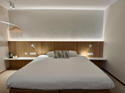 ein Schlafzimmer mit einem großen weißen Bett darin in der Unterkunft Hotel Sirius in Huy