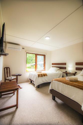 a large bedroom with two beds and a window at Centro Turistico Lafquintue in Ranco