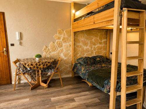 a bedroom with a table and a bunk bed at Studio 4 places - Centre-ville in Ax-les-Thermes