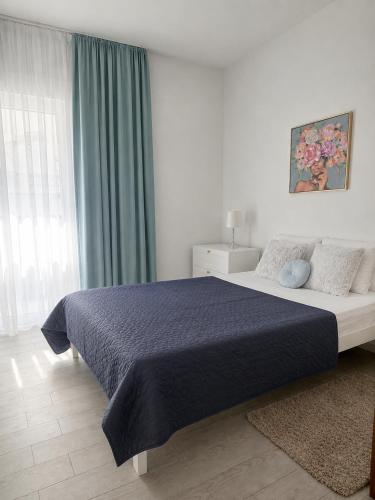 a bedroom with a large bed with a blue blanket at Kamelija LUX in Đenovići