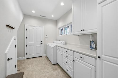 a white kitchen with white cabinets and a sink at Flatlanders Retreat in Twain Harte