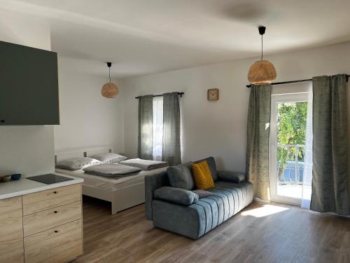 a living room with a couch and a bed at Best Apartman Lelle 2 in Balatonlelle