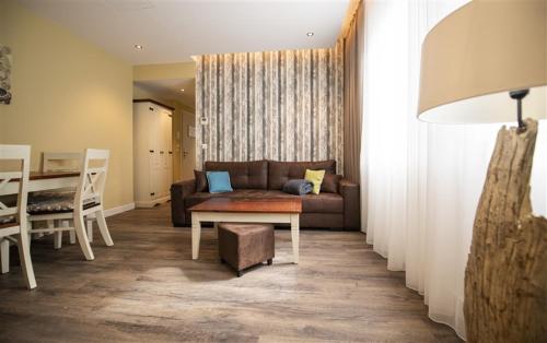 a living room with a couch and a table at Hotel Apartment Central Leipzig-City & Zoo in Leipzig