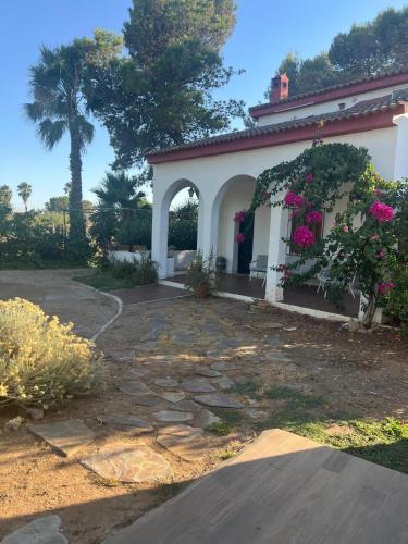 a house with flowers on the side of it at Chalet con piscina en Carmona in Carmona