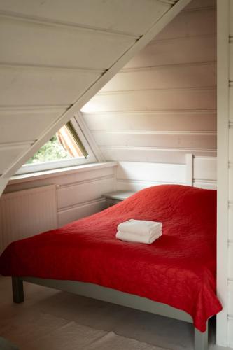 a red bed in a room with a window at Alpejska Szarotka in Nowe Bystre