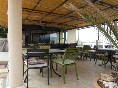 a dining room with tables and chairs and windows at Apartment Valerija in Privlaka