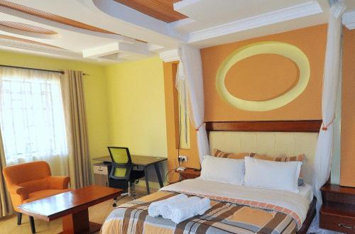 a bedroom with a bed and a table and a desk at Majimbo Whitehouse Resort in Ramogi