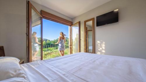 a bedroom with a bed and a large window at Duerming La Rana Sanxenxo in Sanxenxo