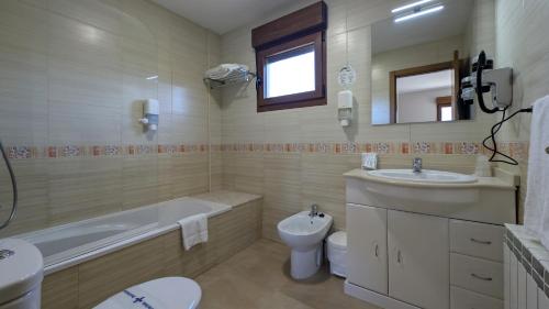 a bathroom with a tub and a toilet and a sink at Duerming La Rana Sanxenxo in Sanxenxo