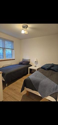 a bedroom with two beds and a window at NordNest in Frederiksværk