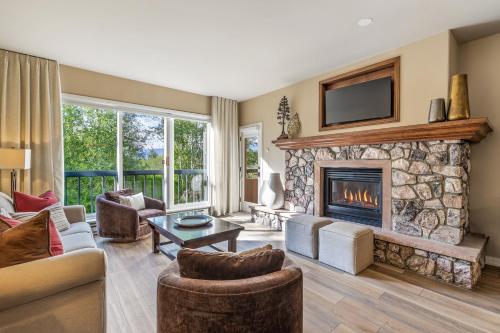 a living room with a fireplace with a tv above it at Walk to Beaver Creek Village - 2BR Condo with Chairlift Views, Pool & Hot Tub in Beaver Creek
