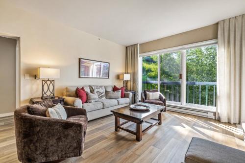 a living room with a couch and a table at Walk to Beaver Creek Village - 2BR Condo with Chairlift Views, Pool & Hot Tub in Beaver Creek