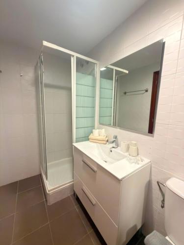 a white bathroom with a sink and a shower at El Boj in Canfranc