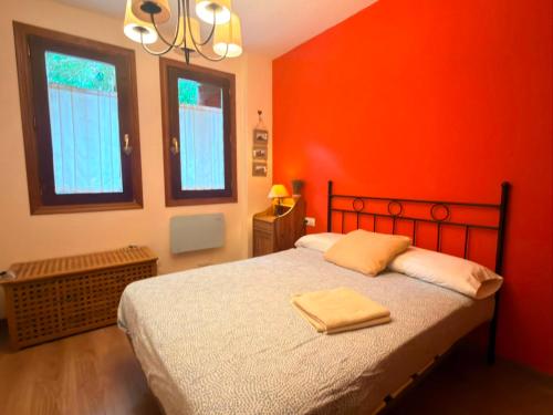 a red bedroom with a bed with two towels on it at El Boj in Canfranc