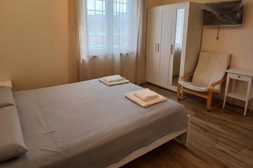 a bedroom with a bed and a chair and a window at Il Rifugio in Franciacorta in Erbusco